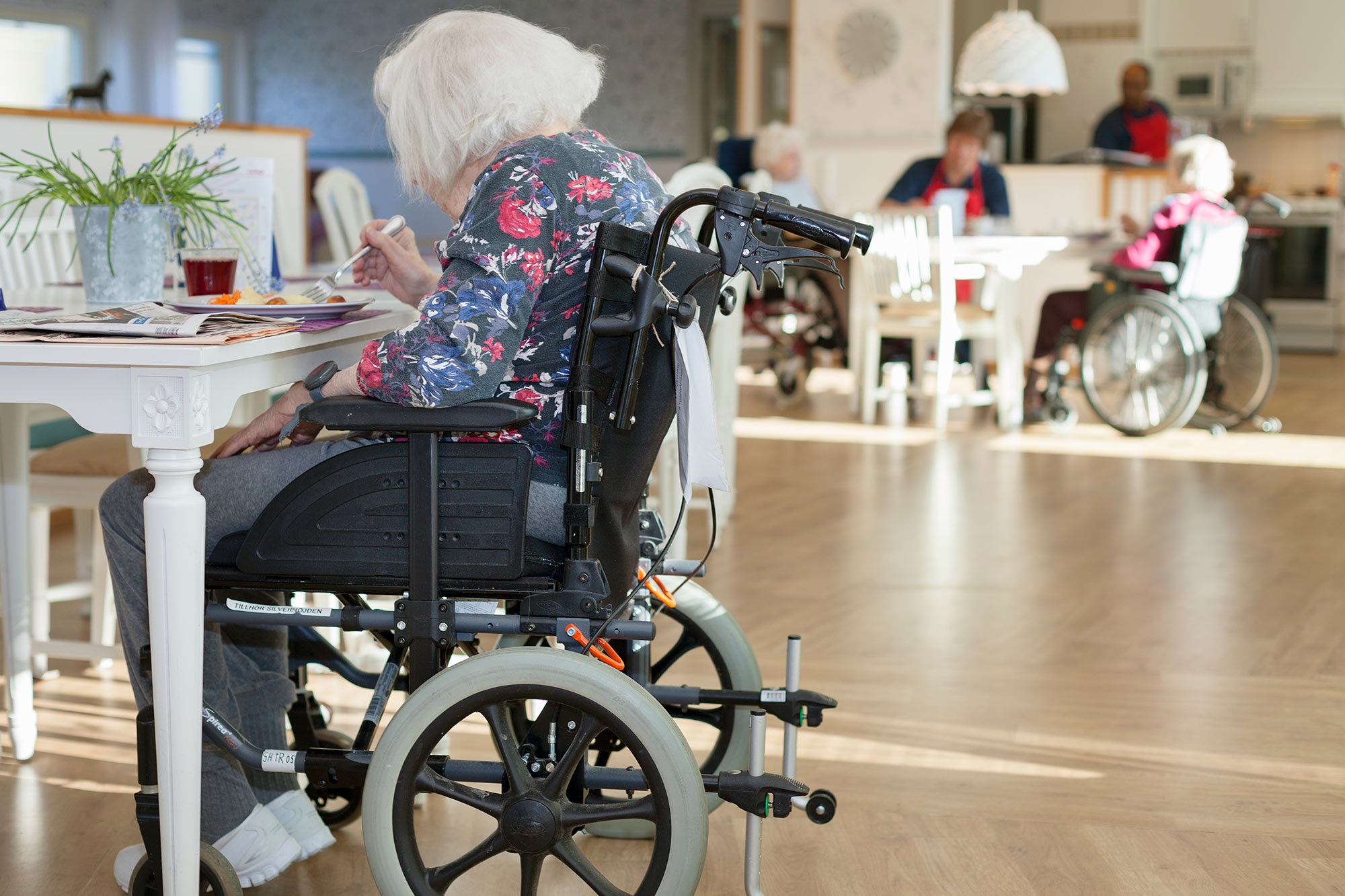 Äldre kvinna som sitter i rullstol på ett äldreboende.